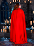Embracing the mood of a candle-lit dungeon, a female model sets the stage for gothic fashion in the BRAM STOKER'S DRACULA Lucy Bustier Gown and Matching Cape in Fire Orange, a standout piece from La Femme en Noir's goth clothing line.