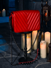 Bathed in the eerie radiance of candle flames, the Gargoyle Sculpture Quilted Crossbody Bag in Blood Red, a product of gothic clothing brand La Femme en Noir's BRAM STOKER'S DRACULA line, makes its presence known.