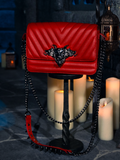 Surrounded by the soft, wavering glow of candles, the Gargoyle Sculpture Quilted Crossbody Bag in Blood Red from La Femme en Noir's BRAM STOKER'S DRACULA collection finds its haunting spot.
