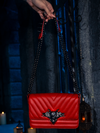 In the company of flickering candles, the haunting allure of the Gargoyle Sculpture Quilted Crossbody Bag in Blood Red from La Femme en Noir's BRAM STOKER'S DRACULA collection comes to the fore.