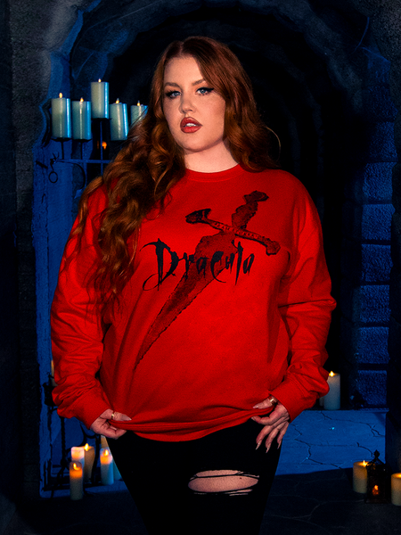 Mesmerizing in her allure, the female human model adorns the "Love Never Dies" Sweatshirt in Red, a striking creation by gothic clothing brand La Femme en Noir in their BRAM STOKER'S DRACULA series.
