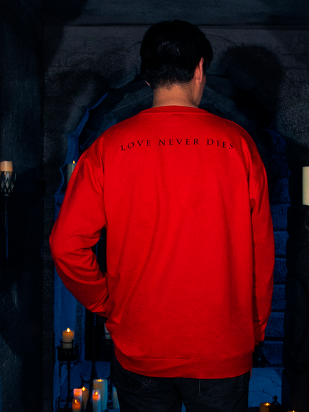 Exuding grace and charm, the stunning female model showcases the "Love Never Dies" Sweatshirt in Red, a bewitching creation by La Femme en Noir in their BRAM STOKER'S DRACULA collection.