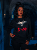 Surrounded by the feeble glimmer of a dungeon's illumination, the mortal mannequin displays the Gargoyle Sculpture Sweatshirt in Black, an artifact from La Femme en Noir's BRAM STOKER'S DRACULA line.