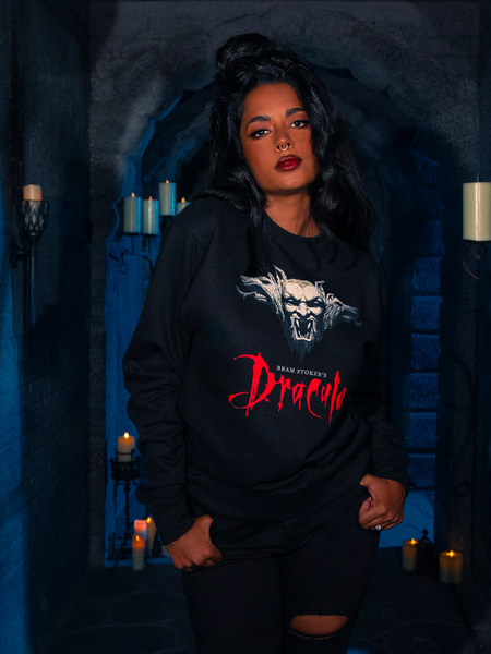 Captured within the gloom of a dimly lit dungeon, the human model parades the Gargoyle Sculpture Sweatshirt in Black, an item drawn from La Femme en Noir's BRAM STOKER'S DRACULA collection.