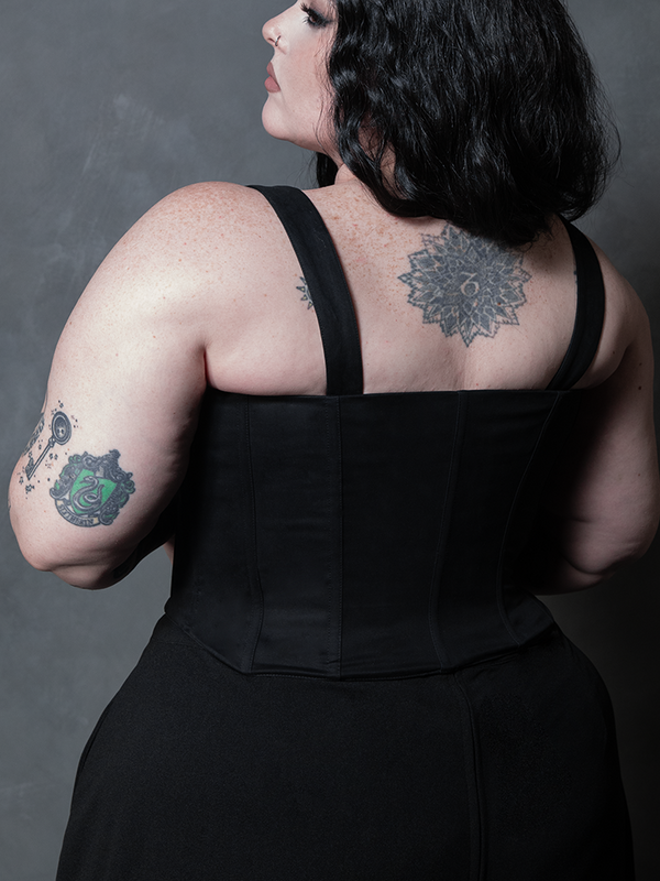 A classic Victorian goth vision is brought to life as a female model wears a structured black cotton corset.