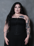 A beautiful vision of Victorian goth sophistication unfolds as a female model wears a deep black cotton corset.