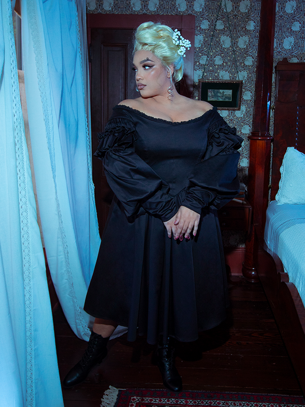 Cloaked in the rich, deep tones of the Ellen Victorian Dress in Black, a female model steps out as a vision of romantic gothic luxury.