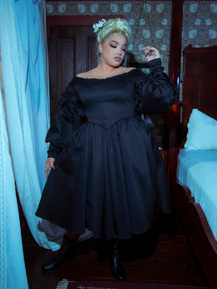 Radiating an enchanting Whimsigoth energy, a female model looks effortlessly mystical in the fluid Ellen Victorian Dress in Black.