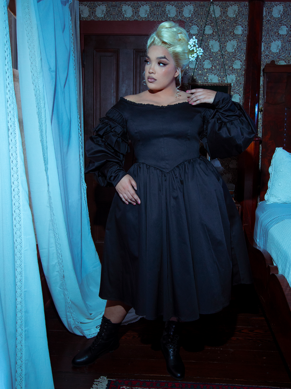 A female model evokes the spirit of a dark fairy tale while wearing the dreamy, romantic Ellen Victorian Dress in Black.