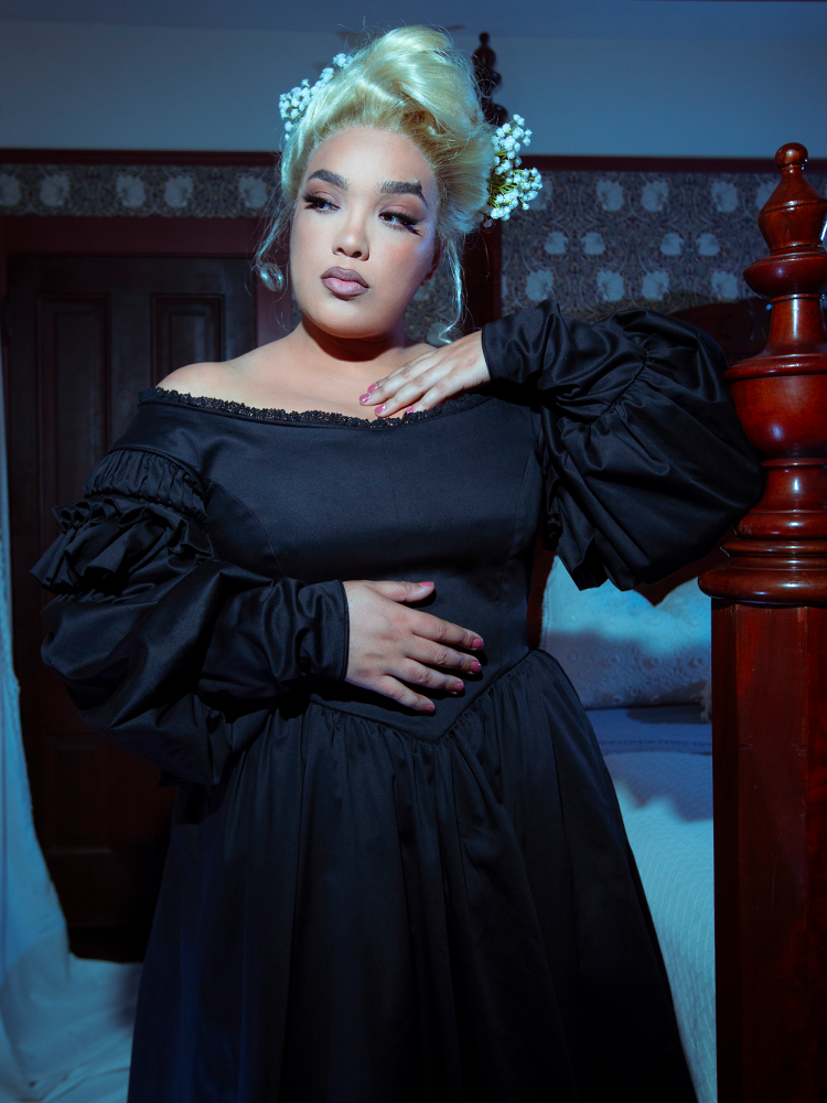 A female model captures the poetic mystery of high-fashion gothic style clothing while wearing the enchanting Ellen Victorian Dress in Black.