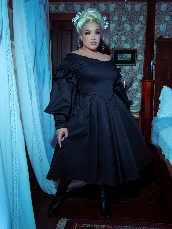 Capturing a moody, ethereal aesthetic, a female model looks utterly spellbinding in the Whimsigoth-inspired Ellen Victorian Dress in Black.