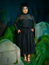 The Funeral Dress in Black drapes you in an aura of timeless mourning elegance. With its flowing silhouette and high neckline, this gown whispers of gothic romance, perfect for somber evenings or moonlit rituals steeped in mystery.