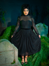 The Funeral Dress in Black is a haunting vision of gothic refinement. Its long, dramatic sleeves and floor-length design capture a mournful elegance, ideal for those who wish to blend darkness with grace in their twilight escapades.