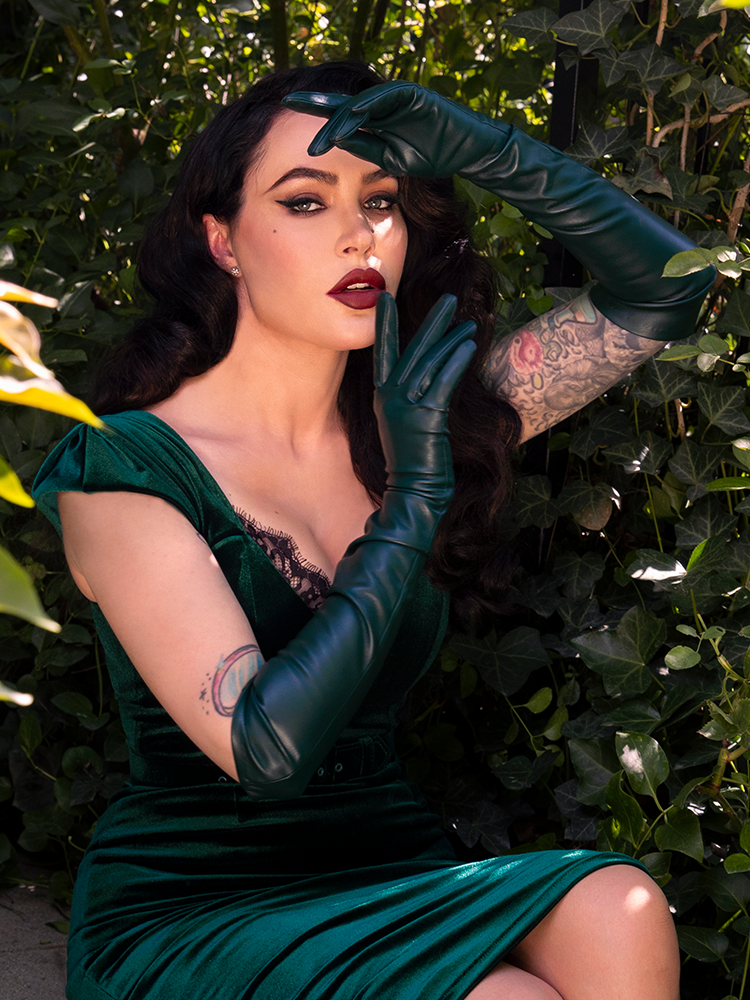 Exuding dark elegance and a moody Whimsigoth aesthetic, a female model showcases these breathtaking hunter green opera gloves, perfect for a modern gothic queen.