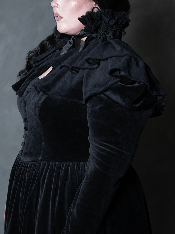 Female model wearing the Haunted Beauty Victorian Mourning Dress & Capelet Set in Black, exuding alternative gothic couture and ethereal dark poise.
