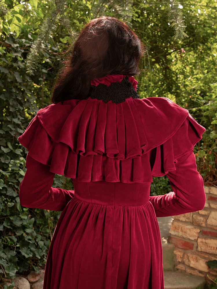 Under flickering candlelight, Micheline Pitt’s Haunted Beauty Capelet in Crimson glows like a forbidden rose—velvet-rich and dangerously divine.