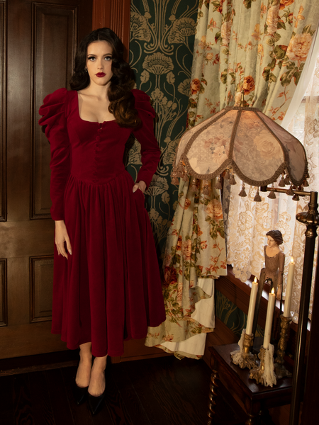 The Haunted Beauty Victorian Dress in Crimson radiates dark romance with its stunning lace sleeves, structured corset-like bodice, and a voluminous skirt for a dramatic vintage silhouette.