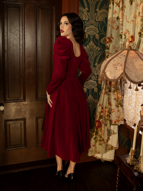 The Haunted Beauty Victorian Dress in Crimson captures timeless elegance with its rich crimson fabric, intricate lace accents, and a regal silhouette inspired by vintage Victorian fashion.