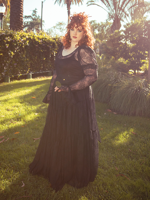 The Juliet Sheer Lace Maxi Dress in Black dances with the essence of romance, its delicate lace and flowing form echoing eternal elegance.