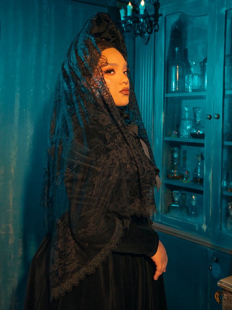 Eclipse of the Heart Lace Mourning Scarf Veil in Black: Step into the shadow of romance with the Eclipse of the Heart Lace Mourning Scarf Veil. This bewitching accessory is woven from premium black lace, designed to drape gracefully over the contours of your face and shoulders, creating an aura of mystique and allure.
