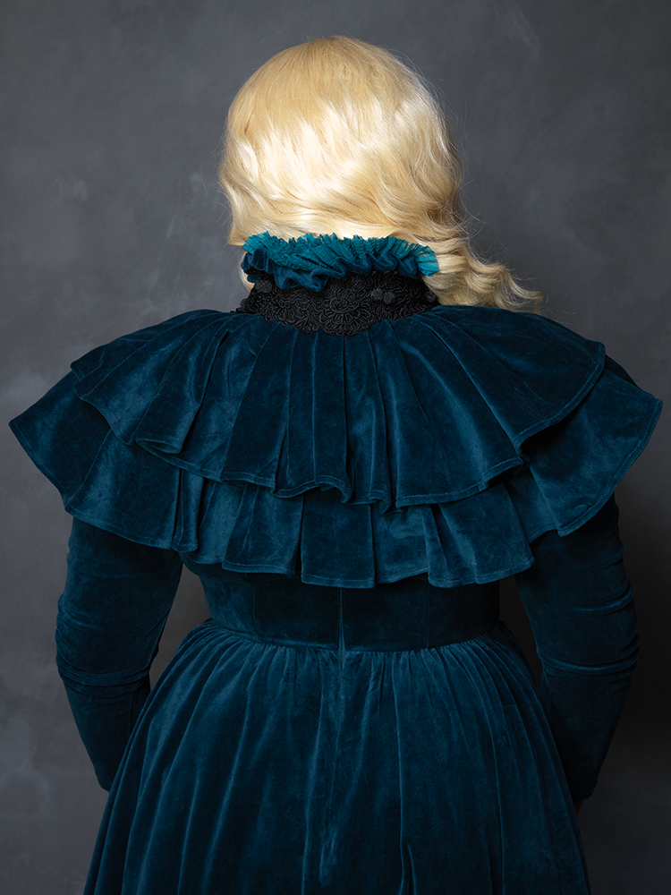 Model styled in the teal CRIMSON PEAK™ Lady Lucille Victorian Dress with Capelet, embodying gothic eveningwear elegance and dramatic sophistication.