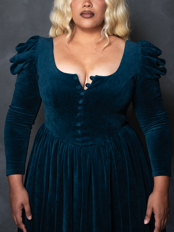 Female model wearing the teal CRIMSON PEAK™ Lady Lucille Victorian Dress with Capelet, portraying romantic goth clothing and spellbinding enchantment.