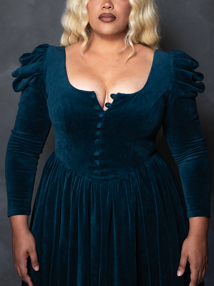 Female model wearing the teal CRIMSON PEAK™ Lady Lucille Victorian Dress with Capelet, portraying romantic goth clothing and spellbinding enchantment.