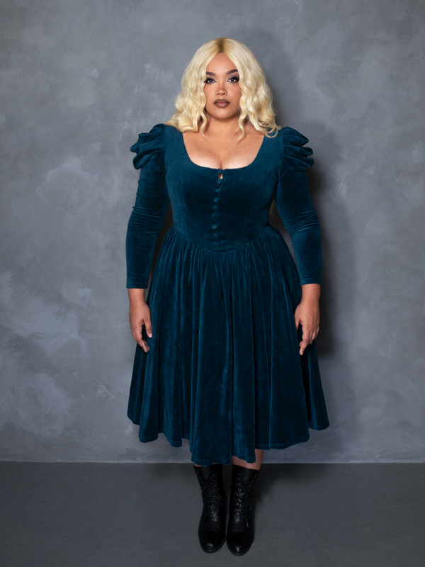 Female model wearing the CRIMSON PEAK™ Lady Lucille Victorian Dress with Capelet in Teal, evoking dark romantic apparel and ethereal moodiness.