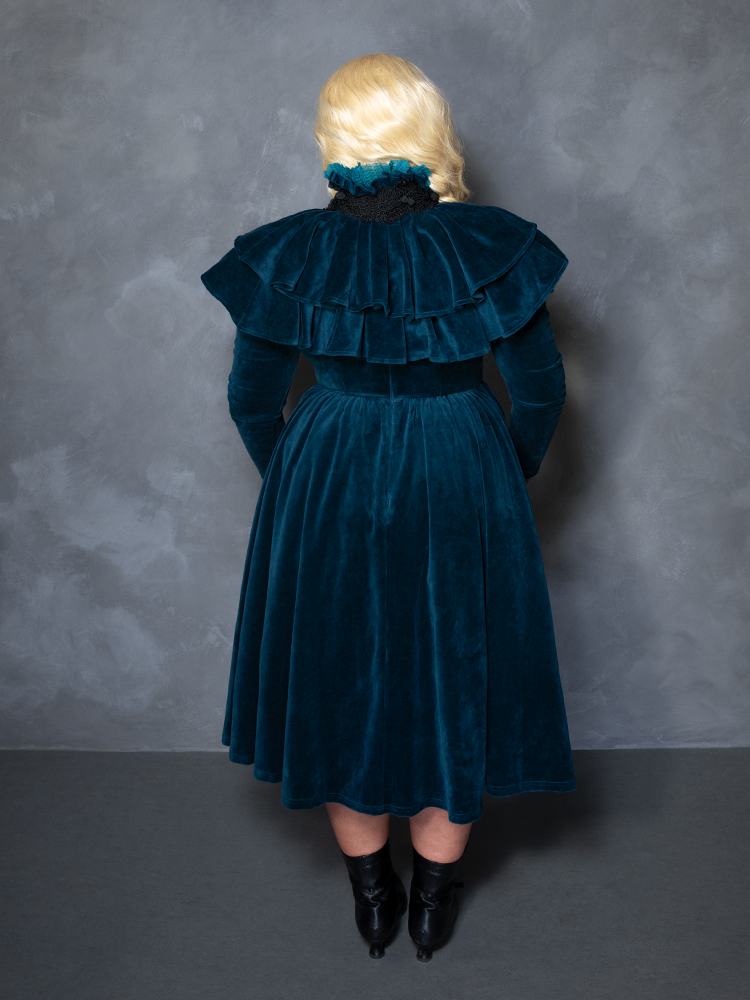 Model styled in the teal CRIMSON PEAK™ Lady Lucille Victorian Dress with Capelet, exuding gothic royalty and enchanted noir style.