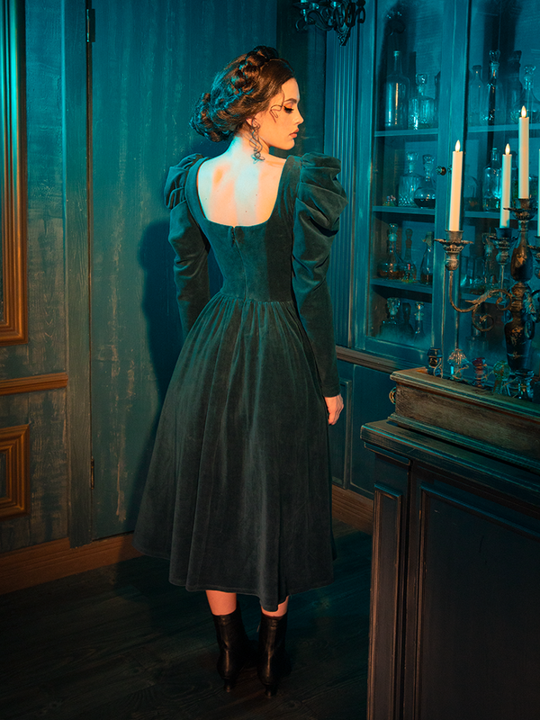 The CRIMSON PEAK™ Lady Lucille Victorian Dress with Capelet in Teal is a vintage-inspired masterpiece, complete with a high-neck design, delicate lace accents, and a beautiful capelet for the perfect gothic touch.