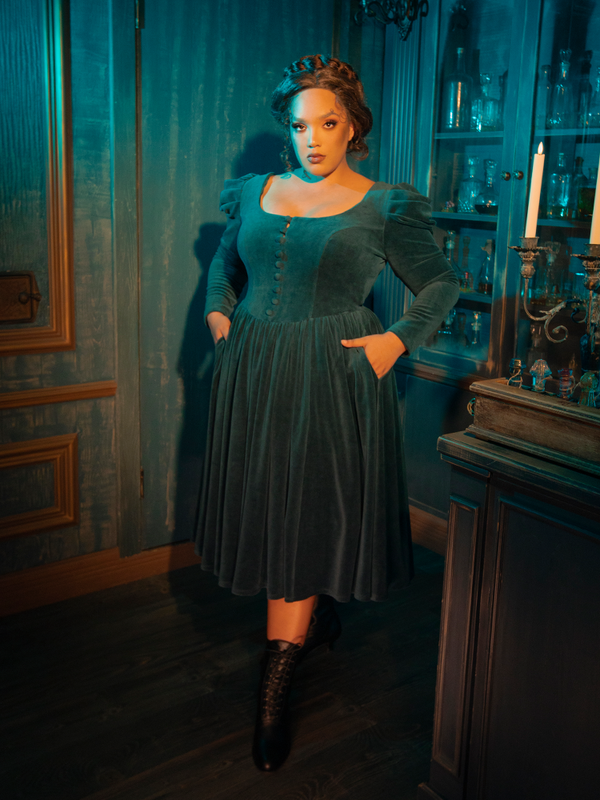 The CRIMSON PEAK™ Lady Lucille Victorian Dress in Teal channels gothic beauty with its ethereal design, high-neck collar, lace detailing, and a capelet that adds an extra layer of romantic mystery.