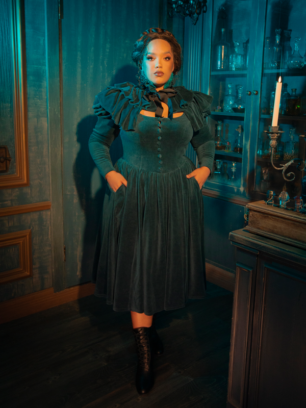 The CRIMSON PEAK™ Lady Lucille Victorian Dress with Capelet in Teal is a gothic lover’s dream, designed with lace detailing, a dramatic capelet, and a silhouette that evokes the elegance of the Victorian era.