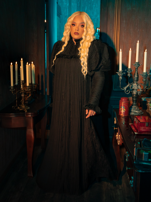 The Lady Mourning Victorian Gown in Black is an embodiment of the enigmatic soul. Its high lace collar and draped sleeves cast a veil of shadows, offering a glimpse into a world of forgotten romance and whispered secrets.