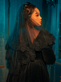 Immersed in a world of pensive contemplation and darkness, the Gothic female model gracefully displays the Ornate Victorian Lady Mourning Veil from La Femme en Noir, unveiling a series of poses that encapsulate the enigmatic essence of this gothic clothing brand.