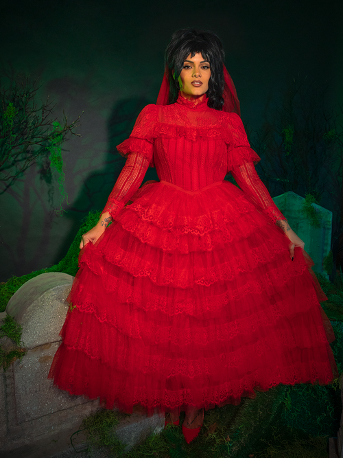 Channel gothic romance with the Beetlejuice™ Lydia Deetz Wedding Dress. Its rich crimson hue and voluminous layers of tulle create a dramatic silhouette, while the high lace collar exudes a vintage, otherworldly charm—perfect for brides who embrace the extraordinary.