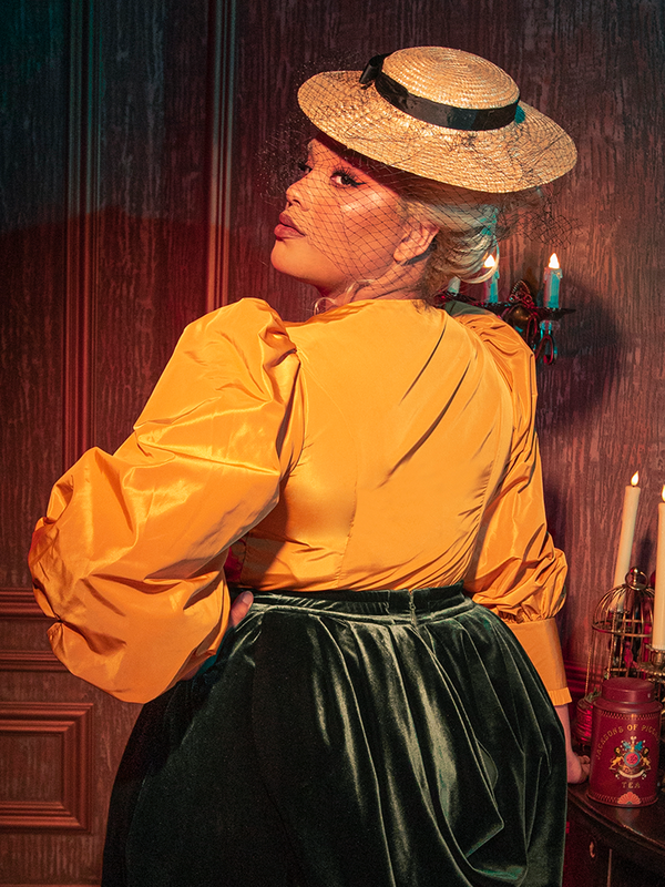 The eerie elegance of the Taffeta Edwardian Blouse in Marigold is revealed as models flaunt this hauntingly beautiful piece from the gothic clothing brand La Femme en Noir.