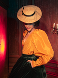 The haunting beauty of the Taffeta Edwardian Blouse in Marigold comes to life as models show it off for La Femme en Noir, the renowned gothic clothing brand.