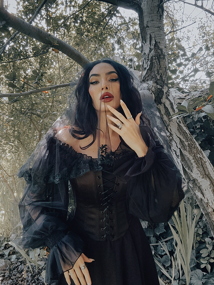 Sheer, voluminous balloon sleeves evoke a sense of Whimsigoth mystery, drifting like shadows around the arms of this enchanting gothic glamour piece.