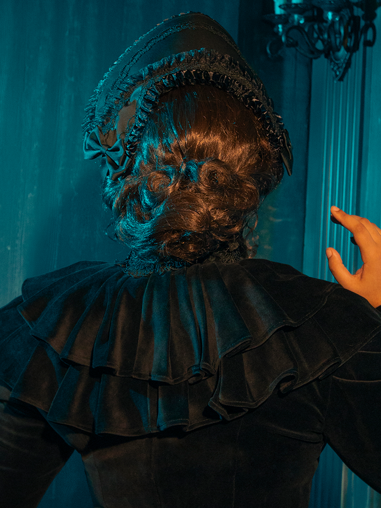 This bonnet blends deep black velvet and intricate lace, offering a poignant nod to Victorian elegance and the art of mourning.