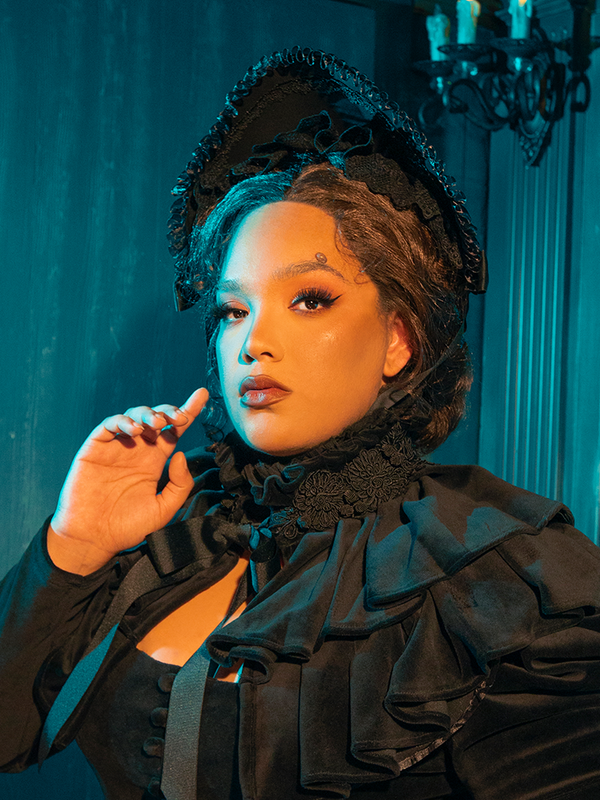  Envelop yourself in the mystery of the Victorian era with this black mourning bonnet, adorned with delicate lace and somber ribbons.