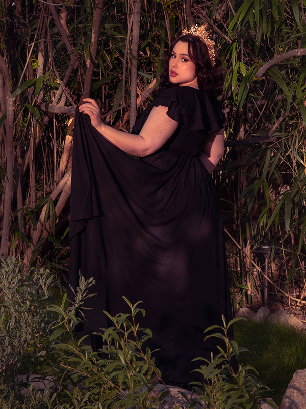 A cinematic editorial shot of the Mythical Goddess Gown in Black, radiating an aura of dark romanticism and power, designed for those who rule the night in gothic style clothing.