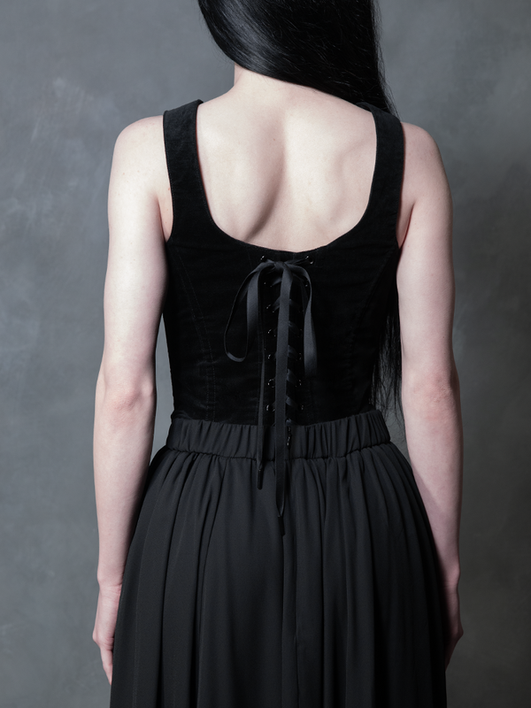 Wrapped in the seductive luxury of a black chiffon skirt, a female model channels timeless gothic couture and effortless edge, an essential piece for the modern woman's dark alternative wardrobe.