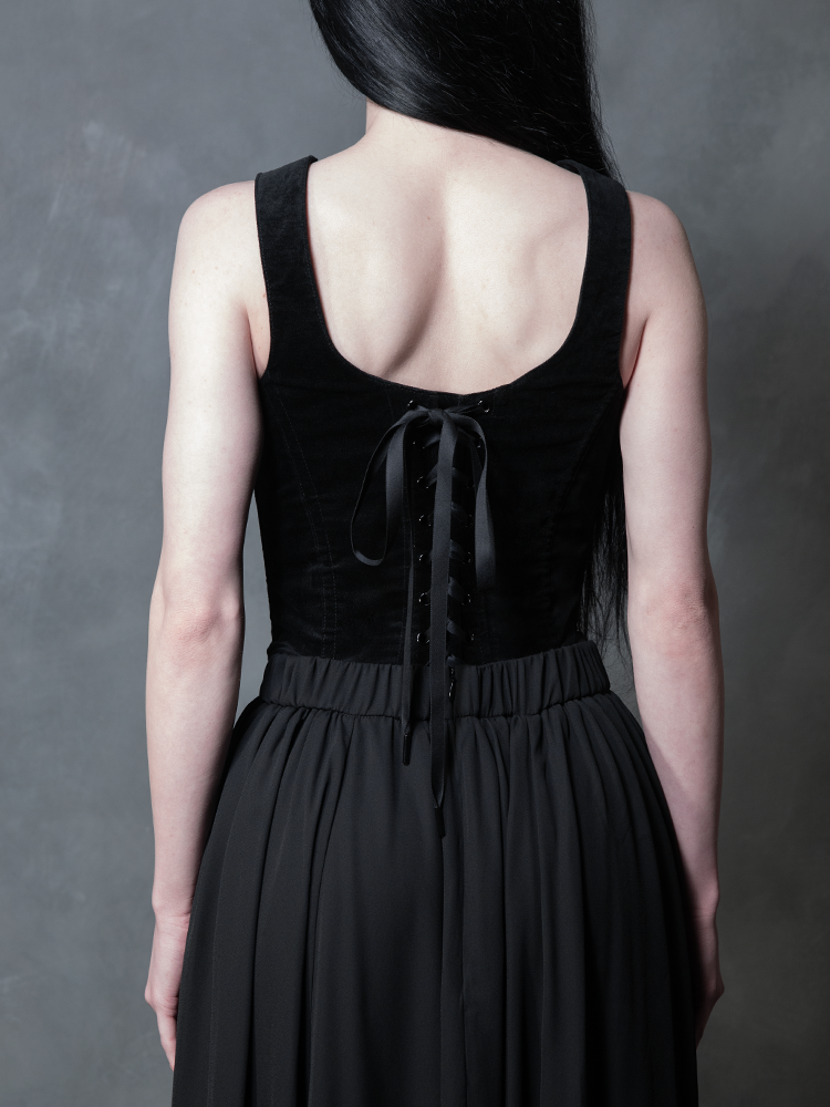 Wrapped in the seductive luxury of a black chiffon skirt, a female model channels timeless gothic couture and effortless edge, an essential piece for the modern woman's dark alternative wardrobe.