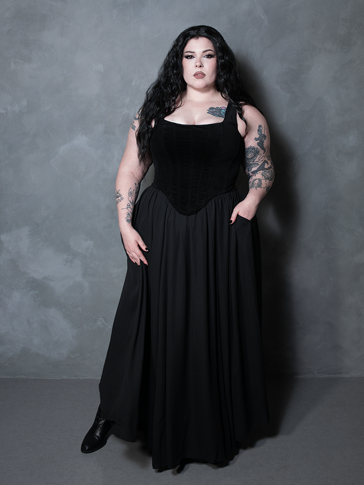 A mesmerizing display of alternative luxury, a female model commands the scene in a flowing black maxi skirt that defines the pinnacle of contemporary gothic style clothing.
