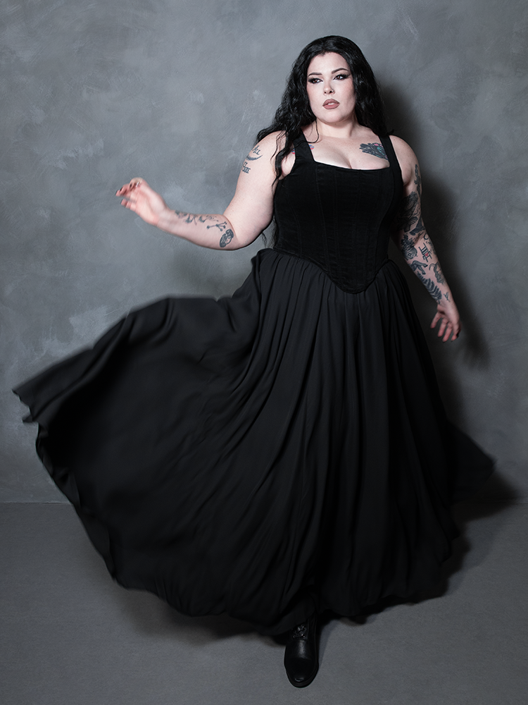 Capturing the very essence of dark glamour, a female model wears an opulent black chiffon skirt that effortlessly transitions from a sunlit afternoon to a midnight romance.