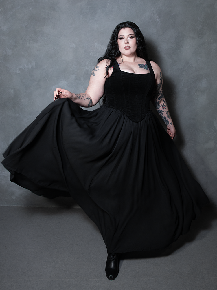Embodying the alluring spirit of high-fashion alternative wear, a female model wears a fluid black chiffon dress skirt that brings a poetic, gothic-inspired luxury to life.