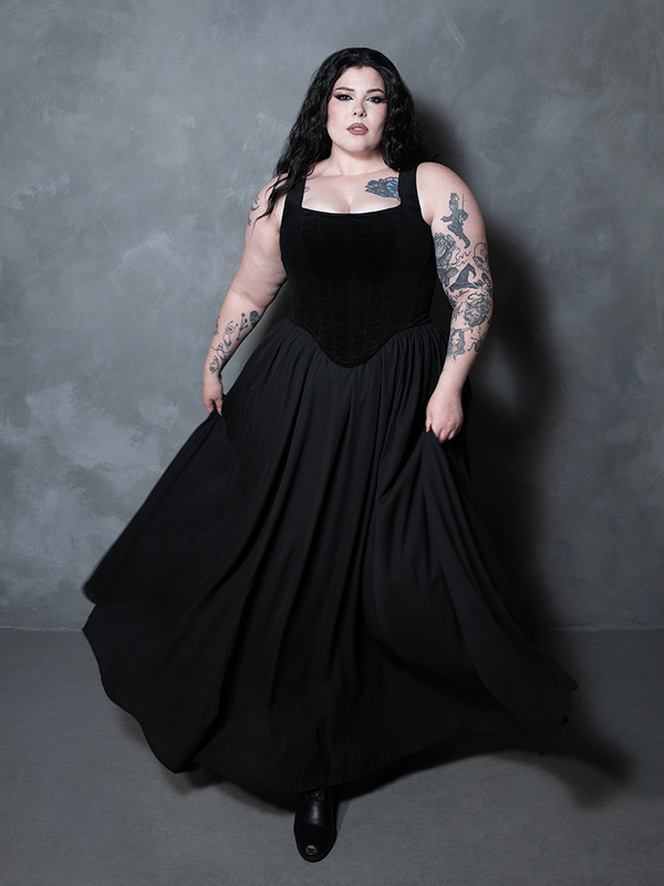 A captivating portrait of premium alternative fashion, a female model showcases a sweeping black chiffon piece that perfectly marries high-fashion romance with a moody aesthetic.