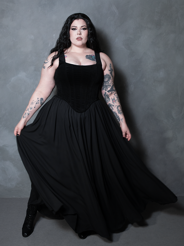 Steeped in cinematic mystery, a female model brings a premium touch of gothic romanticism to life, showcasing how a sheer black maxi skirt can anchor an entire dark luxury look.
