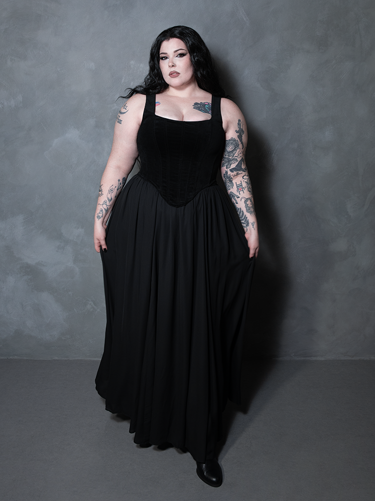 Steeped in mystery and sophisticated edge, a female model showcases a flowing black chiffon skirt that brings a timeless, romantic weight to contemporary fashion.
