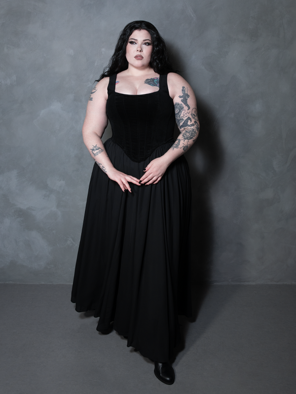 A female model showcases high-end whimsigoth fashion in a stunning black velvet corset designed for the modern romantic goth.